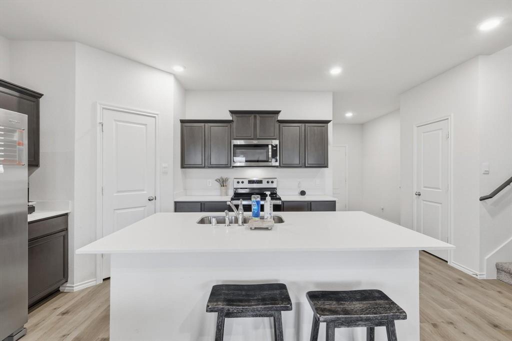 1354 Turkey Run Drive Denton, TX 76207 - Photo 8 of 29 a kitchen with a sink a microwave and cabinets