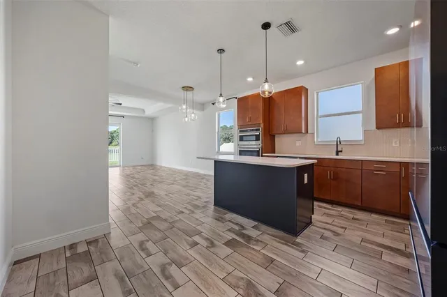 a large kitchen with stainless steel appliances granite countertop a stove a sink and a refrigerator