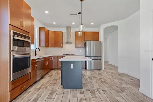 a kitchen with stainless steel appliances granite countertop a refrigerator a oven a sink and a oven