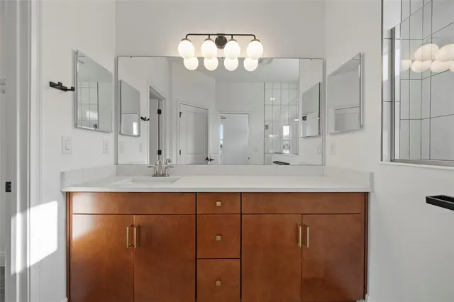 a view of a hallway with wooden floor and a bathroom