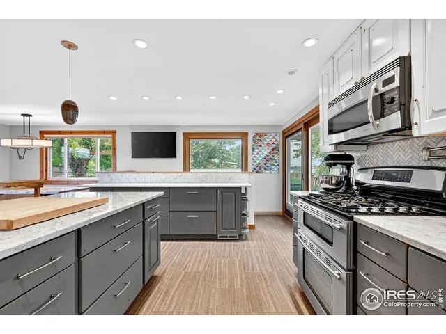 a kitchen with stainless steel appliances granite countertop a stove a sink and a microwave