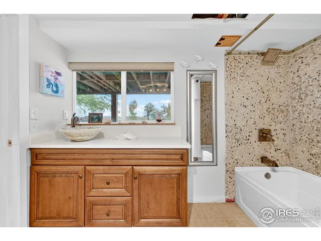 a bathroom with a bathtub a sink and a window