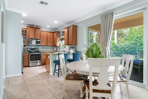 a kitchen with a table chairs microwave and cabinets