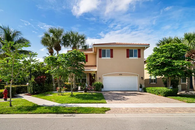 a front view of a house with a yard and a garage