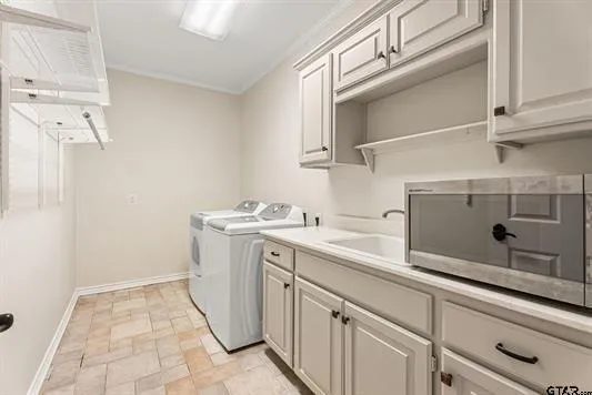 a utility room with cabinets washer and dryer