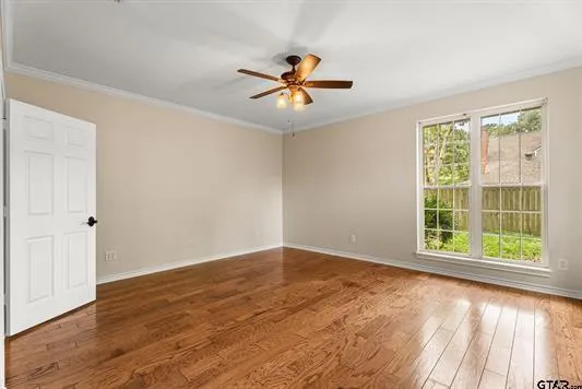 a view of an empty room with window and wooden floor