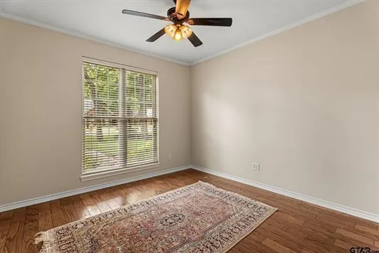 a view of an empty room with a window and wooden floor