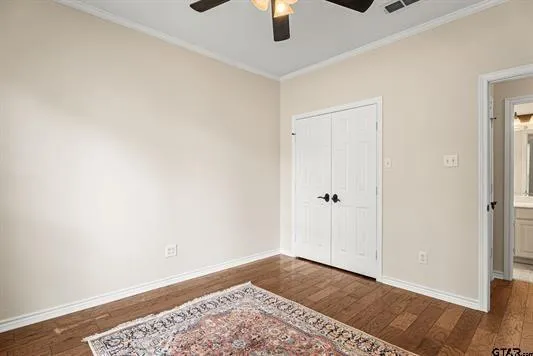 an empty room with a hardwood and ceiling fan