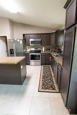 a kitchen with wooden cabinets and stainless steel appliances
