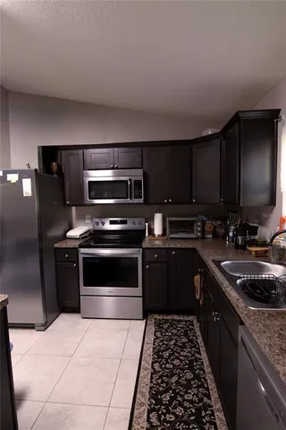 a kitchen with stainless steel appliances granite countertop a stove a sink and a microwave