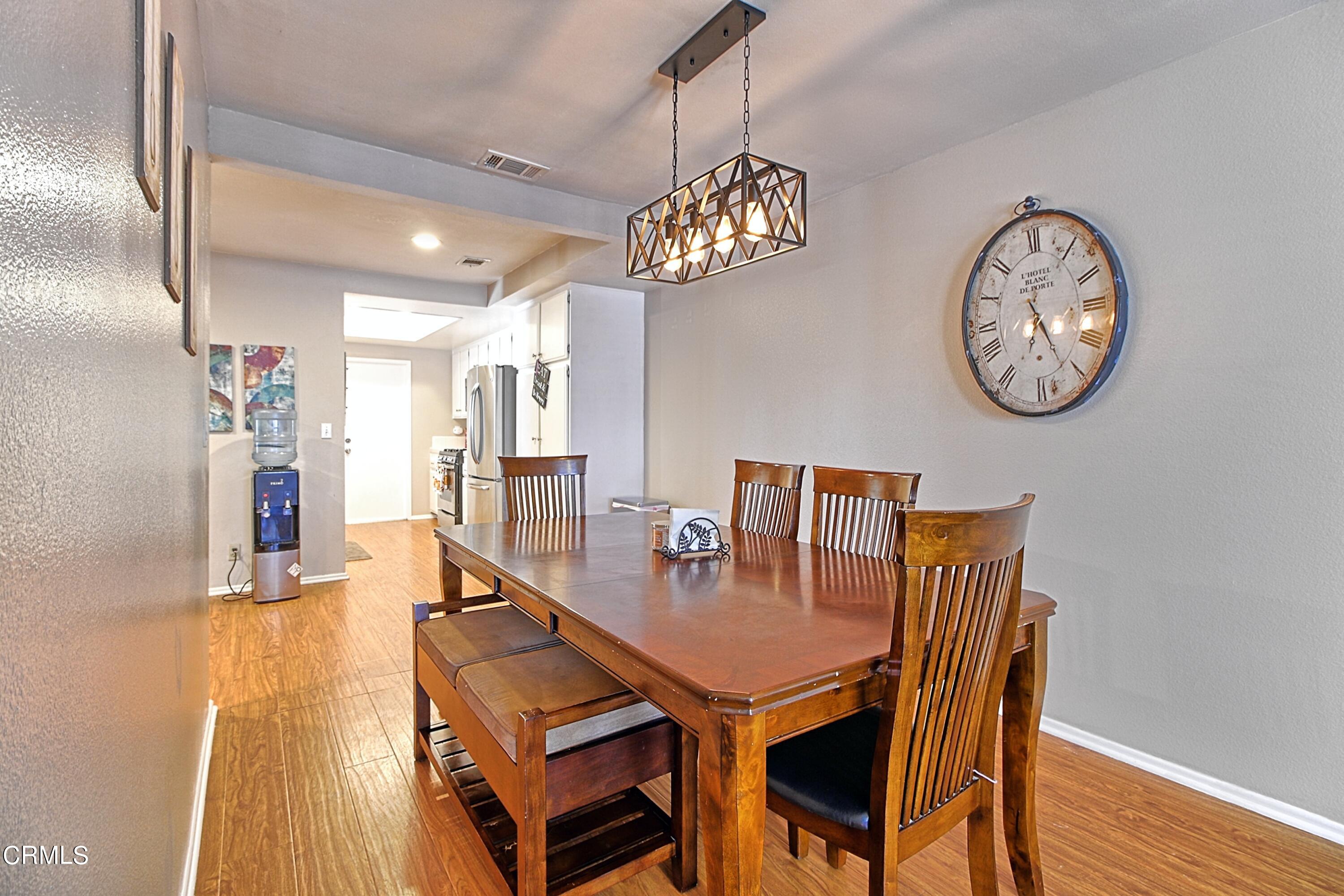1801 Masthead Drive Oxnard, CA 93035 - Photo 15 of 27 a dining room with wooden floor a chandelier a wooden table and chairs