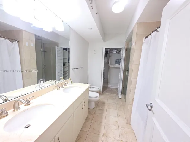 a spacious bathroom with a double vanity sink a mirror and a bathtub