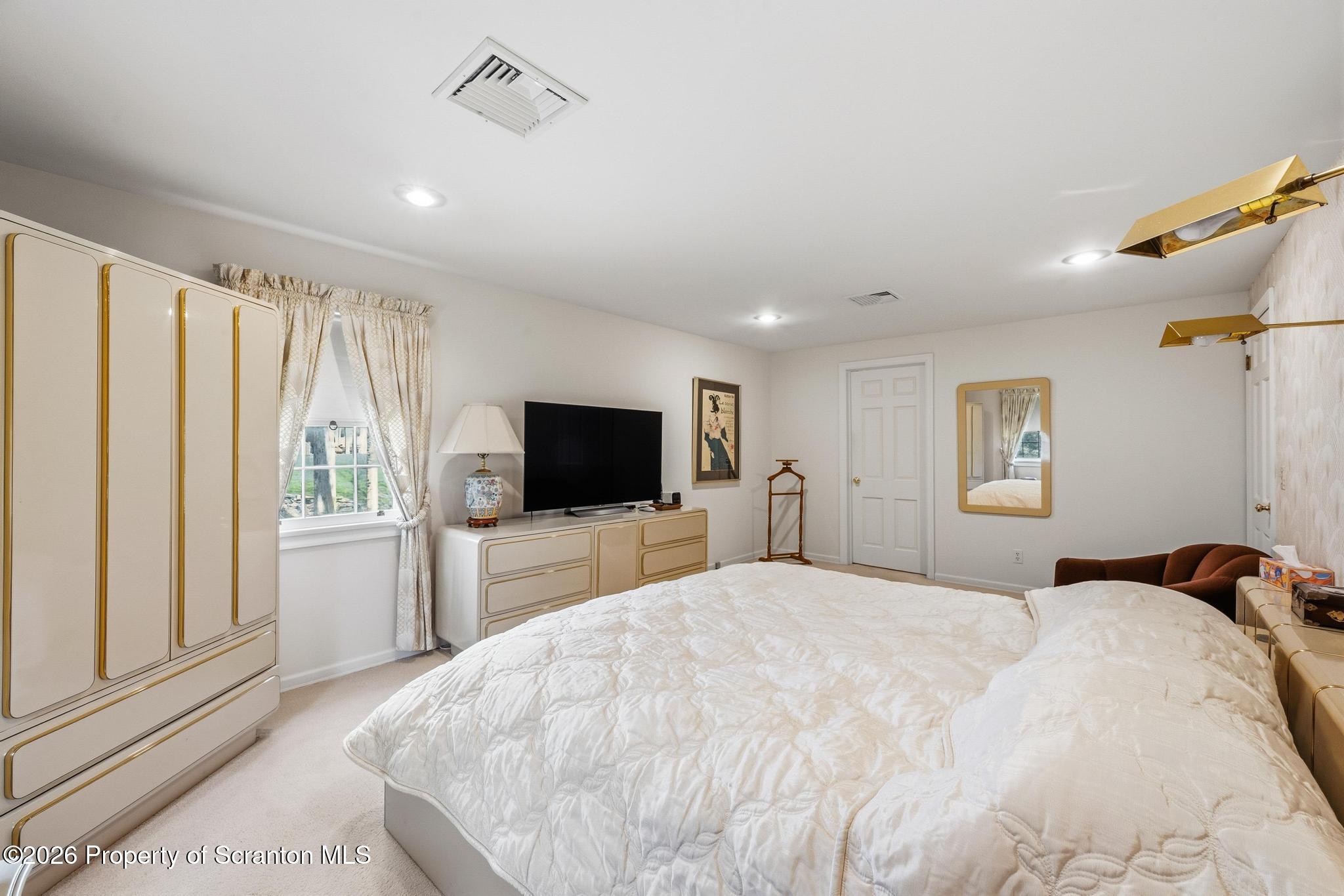 202 Woodlea Road Glenburn, PA 18414 - Photo 16 of 28 a bedroom with a bed and a flat screen tv