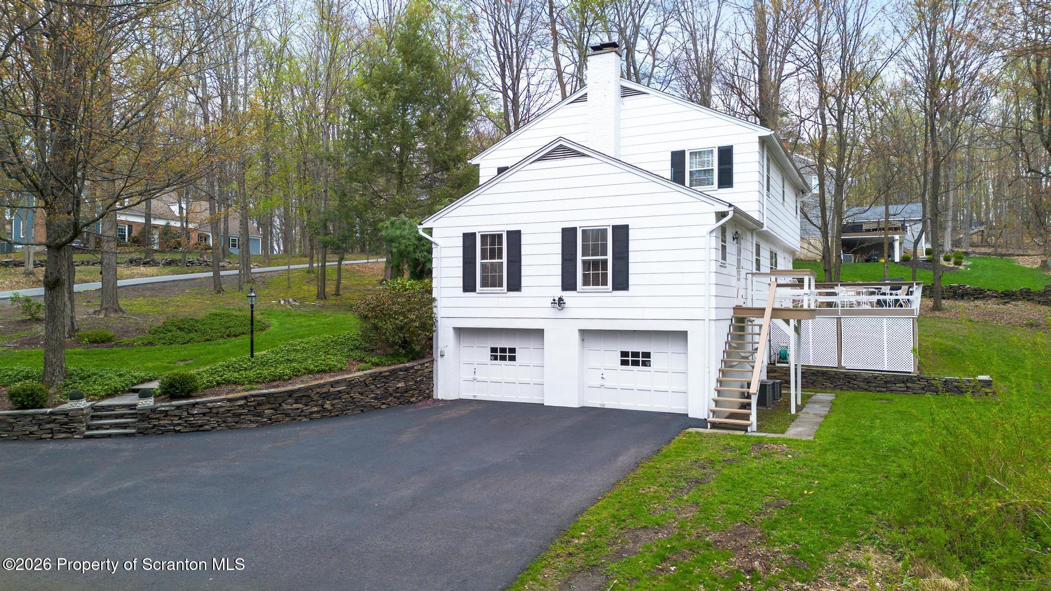 202 Woodlea Road Glenburn, PA 18414 - Photo 24 of 28 a view of a white house next to a yard with big trees