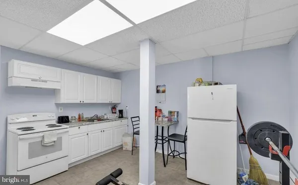 a kitchen with a refrigerator a stove a sink and cabinets