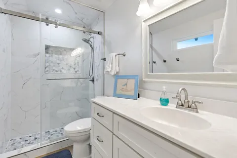 a bathroom with a sink a toilet and shower