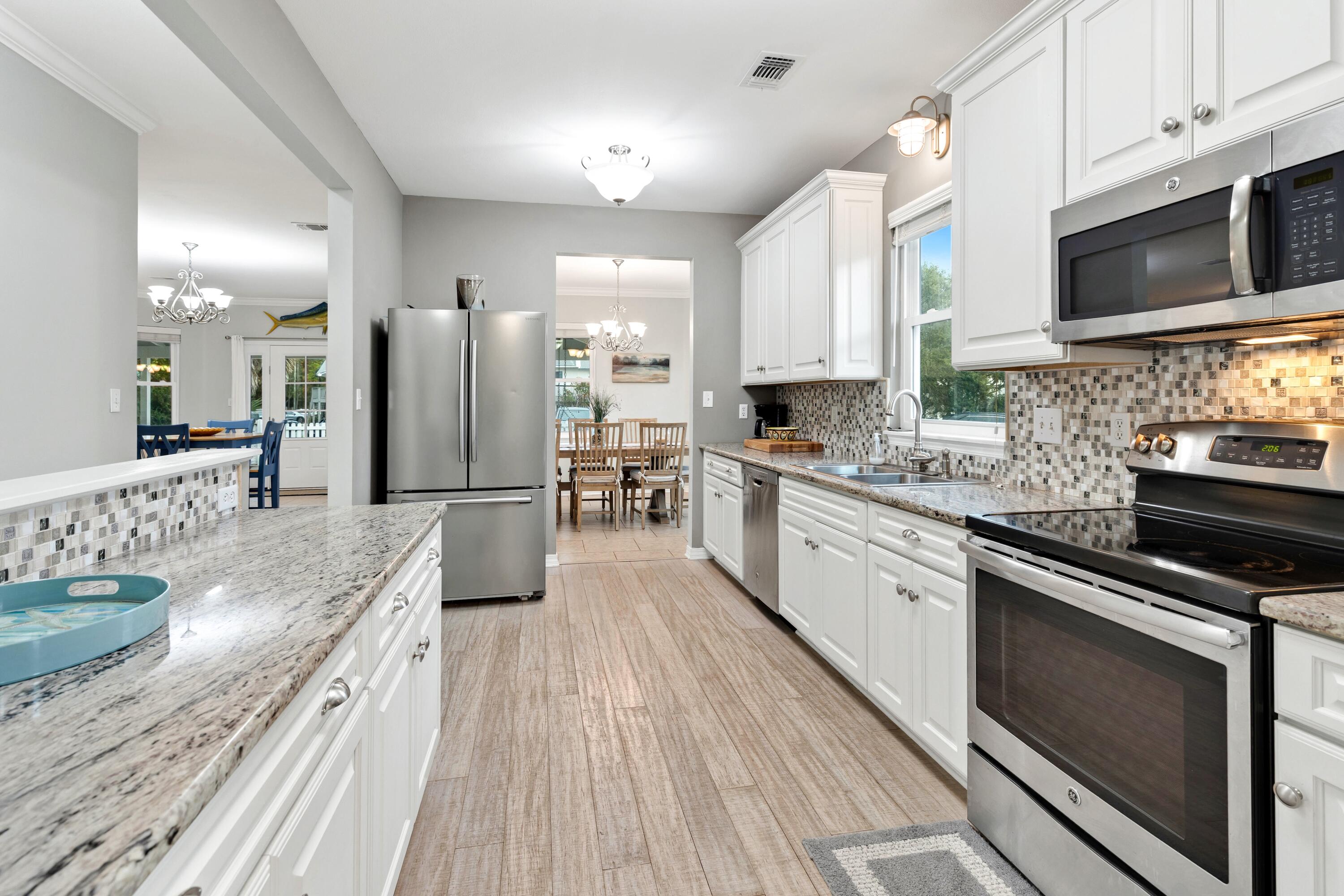 57 Pelayo Avenue Santa Rosa Beach, FL 32459 - Photo 7 of 43 a kitchen with stainless steel appliances kitchen island granite countertop a stove refrigerator and microwave