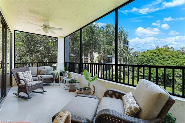 a balcony with chairs and a potted plant