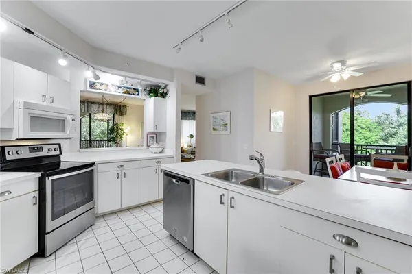 a dining room with furniture large windows and a chandelier