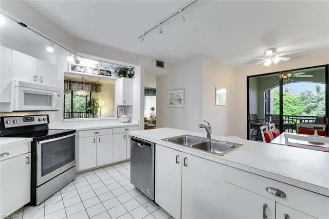 a dining room with furniture large windows and a chandelier