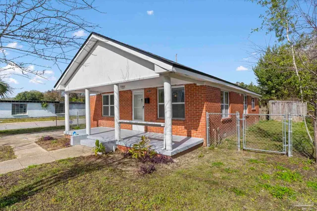 a view of a house with backyard and sitting area