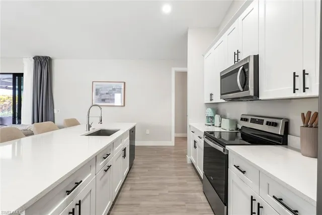 a kitchen with stainless steel appliances granite countertop a sink and a stove
