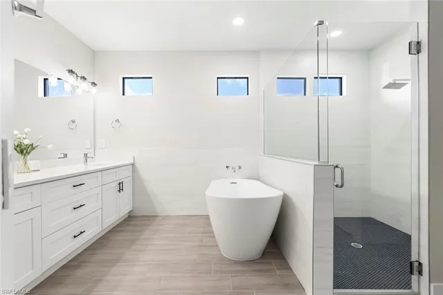 a spacious bathroom with a double vanity sink mirror and bathtub