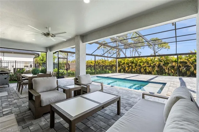 a living room with patio furniture and a large window
