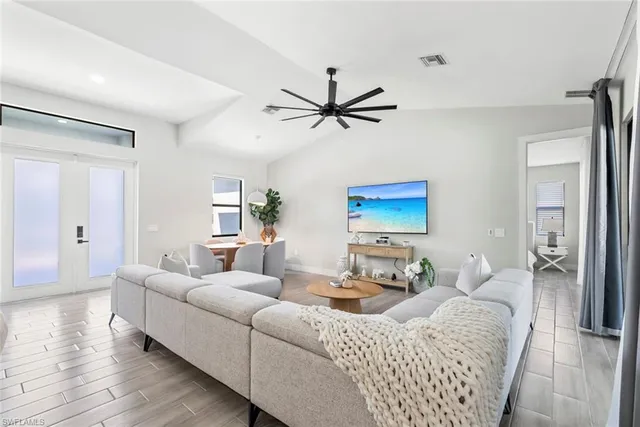 a living room with furniture a bed and a ceiling fan