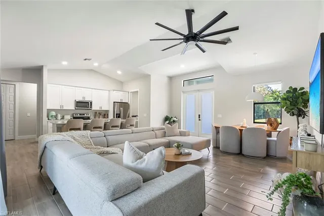 a living room with furniture kitchen view and a large window