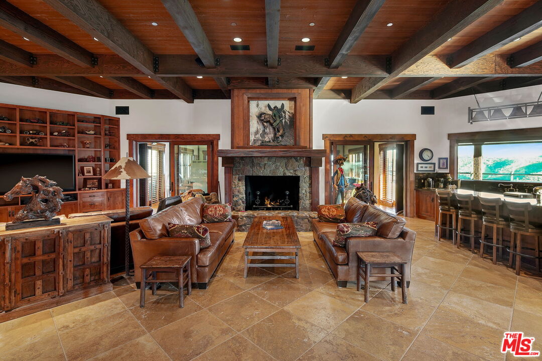 12486 Yerba Buena Road Malibu, CA 90265 - Photo 12 of 68 a living room with furniture a fireplace and a flat screen tv