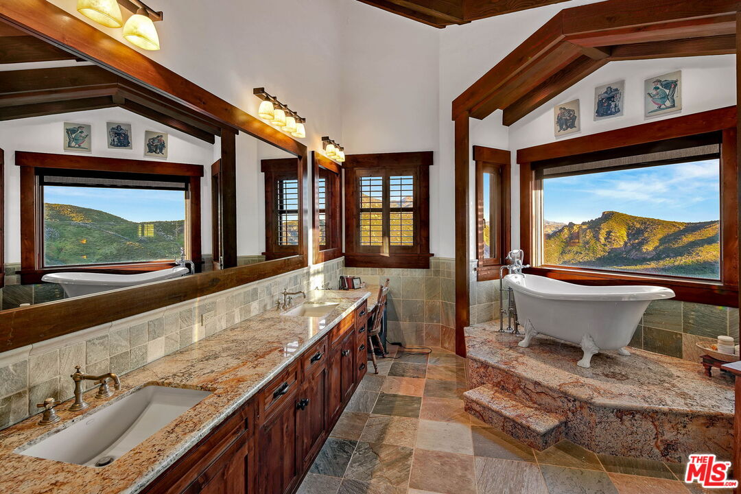 12486 Yerba Buena Road Malibu, CA 90265 - Photo 23 of 68 a bathroom with a granite countertop sink mirror and window