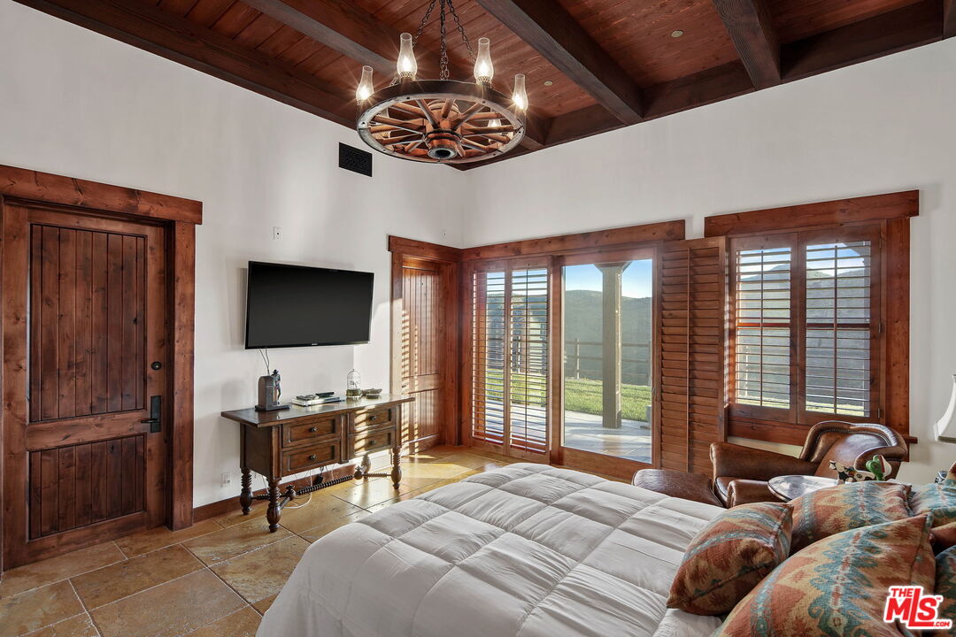 12486 Yerba Buena Road Malibu, CA 90265 - Photo 28 of 68 a bedroom with furniture and a flat screen tv