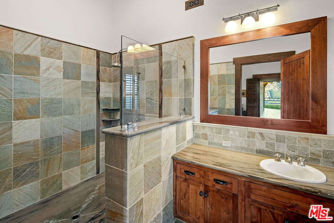 12486 Yerba Buena Road Malibu, CA 90265 - Photo 31 of 68 a bathroom with a double vanity sink mirror and shower