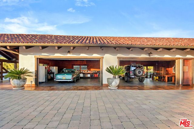 a view of a table and chairs under an umbrella in a backyard