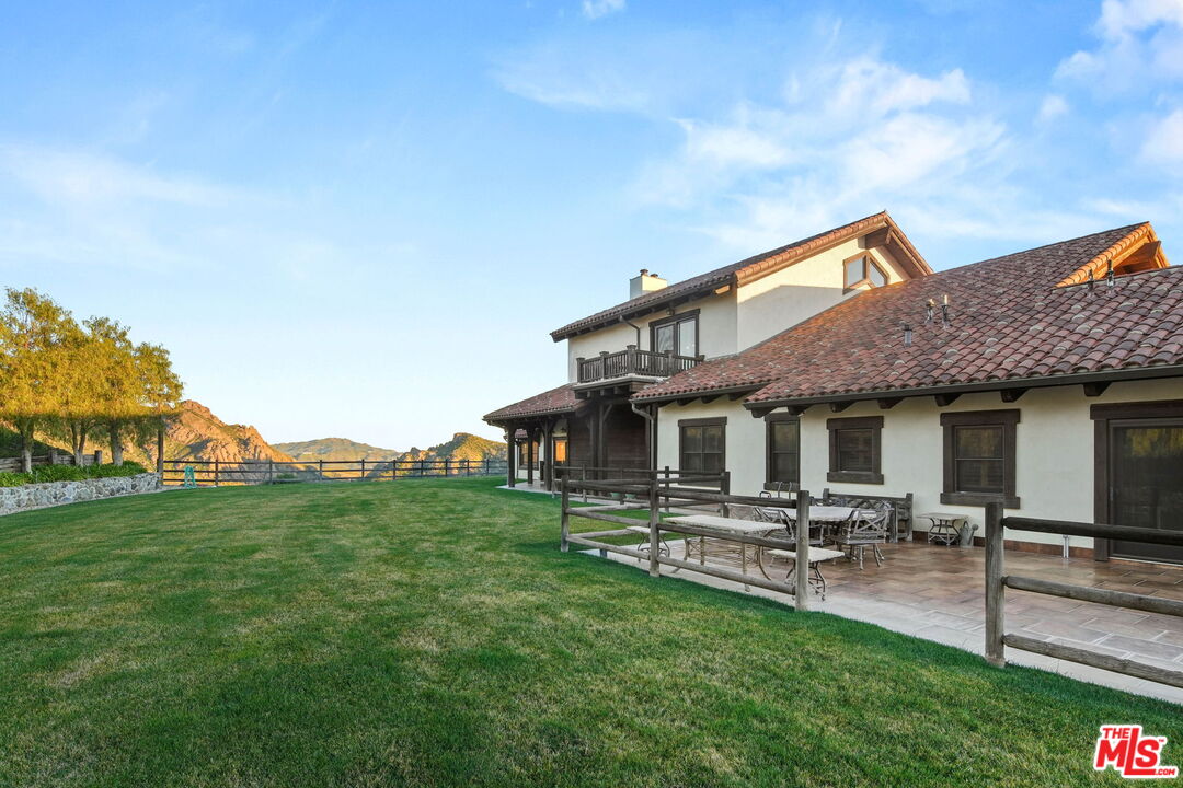12486 Yerba Buena Road Malibu, CA 90265 - Photo 34 of 68 a backyard of a house with table and chairs