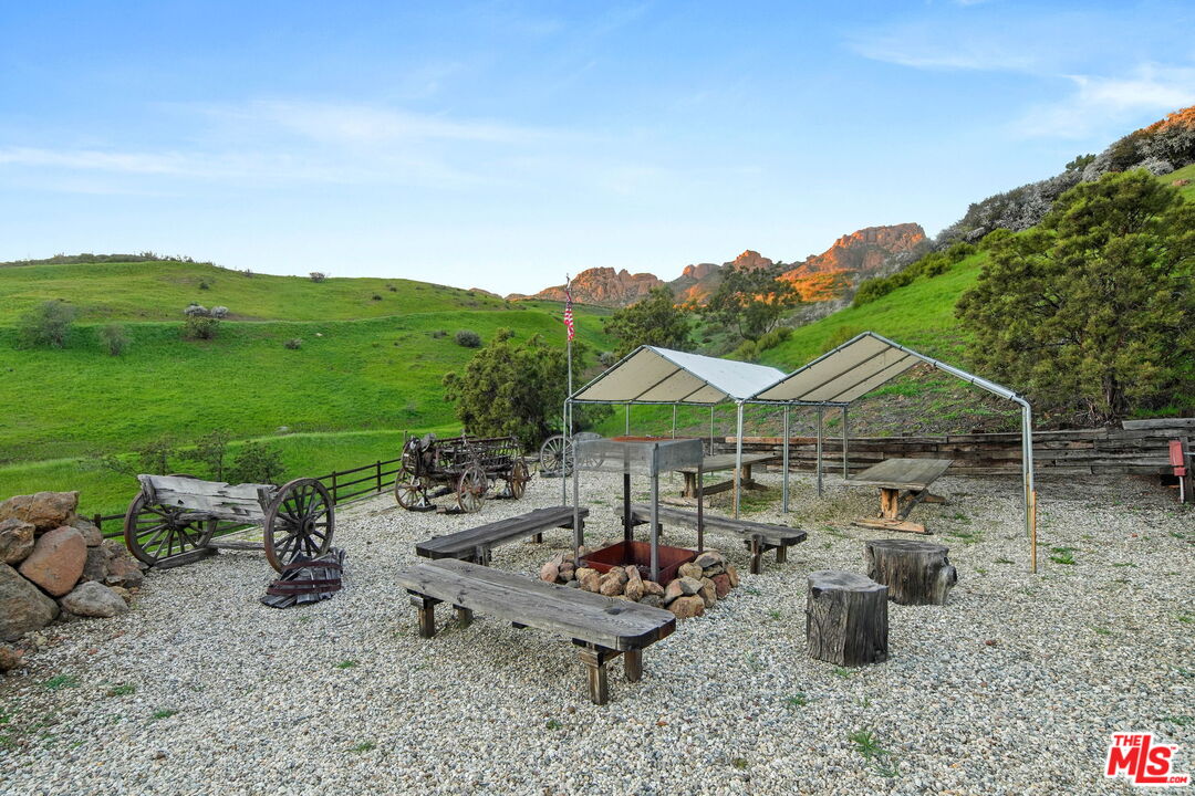 12486 Yerba Buena Road Malibu, CA 90265 - Photo 43 of 68 a view of a table and chairs under an umbrella in a backyard
