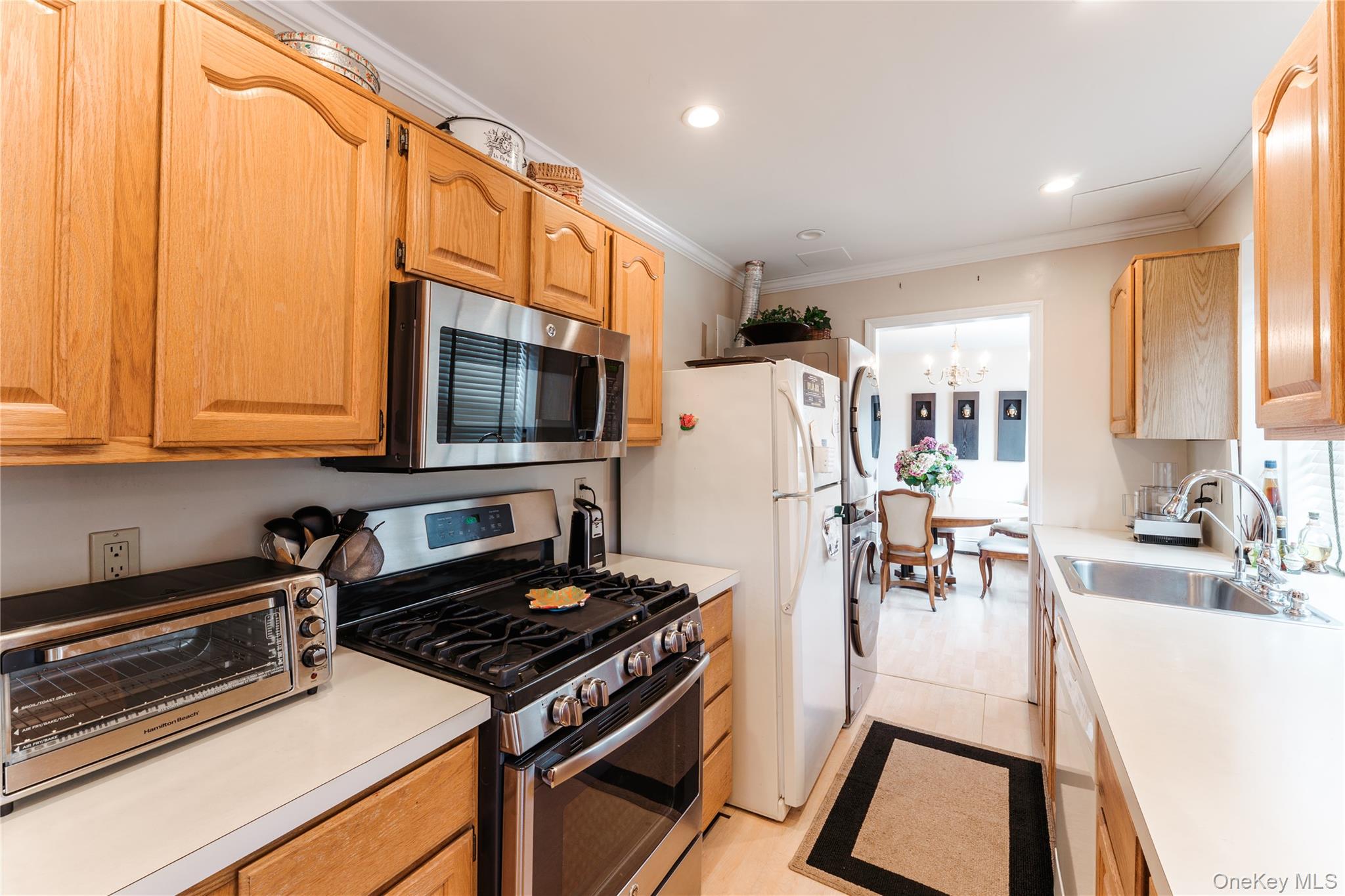 200 South Middle Neck Road, Unit F6 Great Neck, NY 11021 - Photo 6 of 16 a kitchen with stainless steel appliances a stove a sink a microwave and cabinets