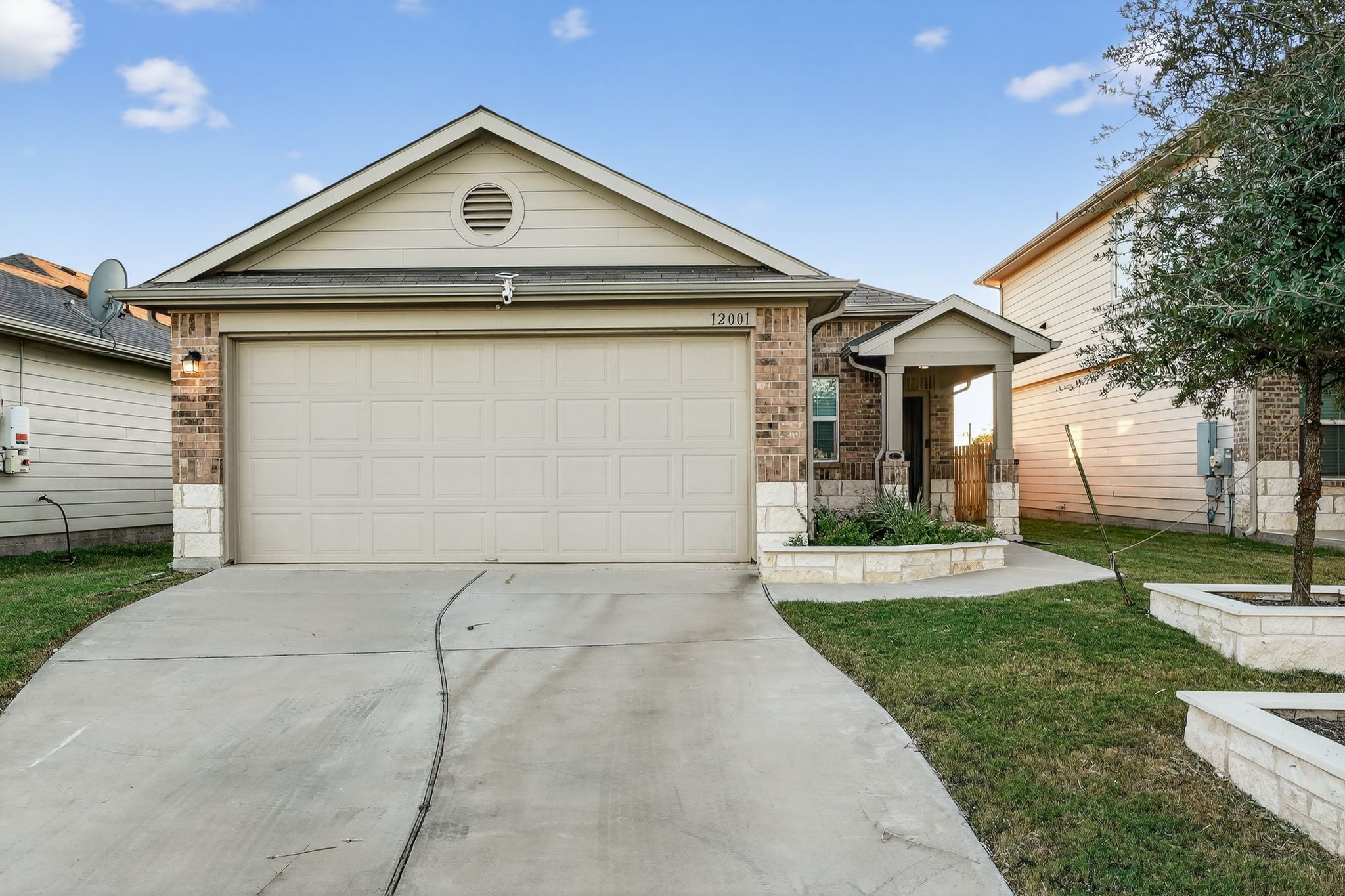 12001 Riprap Drive Manor, TX 78653 - Photo 1 of 1 Ranch-style house featuring brick siding, driveway, an attached garage, and a front lawn