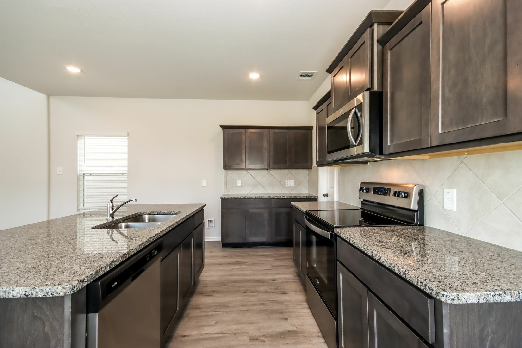 15226 Estrella Road West Houston, TX 77073 - Photo 4 of 13 a kitchen with granite countertop kitchen island a sink stove and microwave