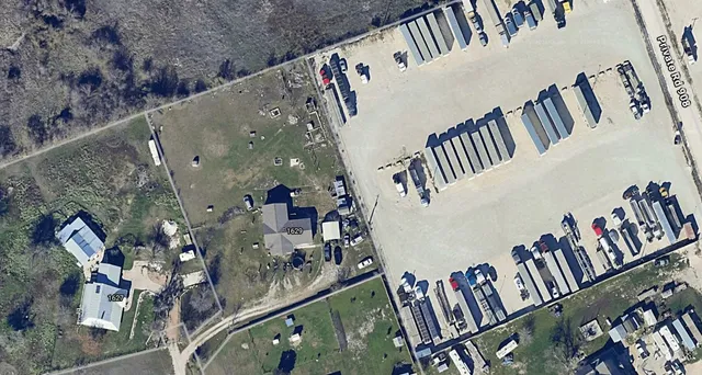 an aerial view of a house with a garden and trees all around