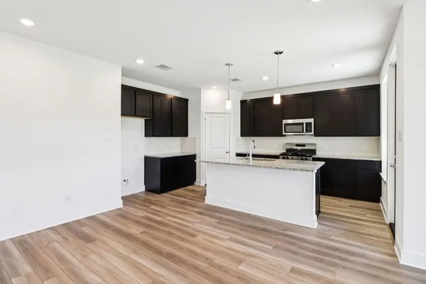 a view of kitchen with sink microwave and refrigerator