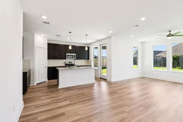 a view of kitchen with granite countertop stainless steel appliances stove sink and cabinets