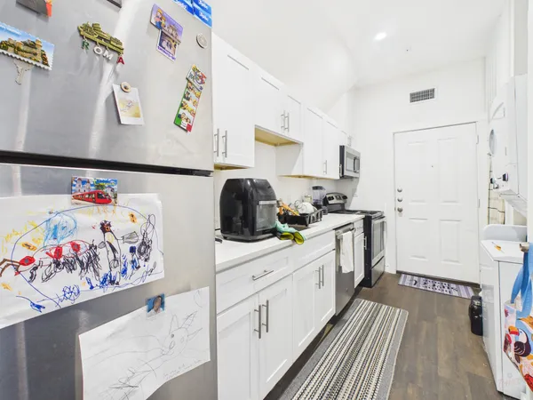 a kitchen with white cabinets stove and white appliances