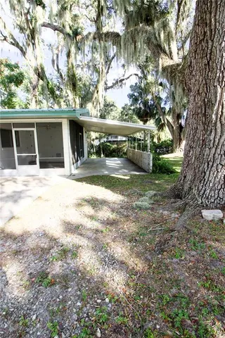 a front view of a house with a yard and large trees