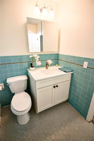 a bathroom with a toilet sink and mirror