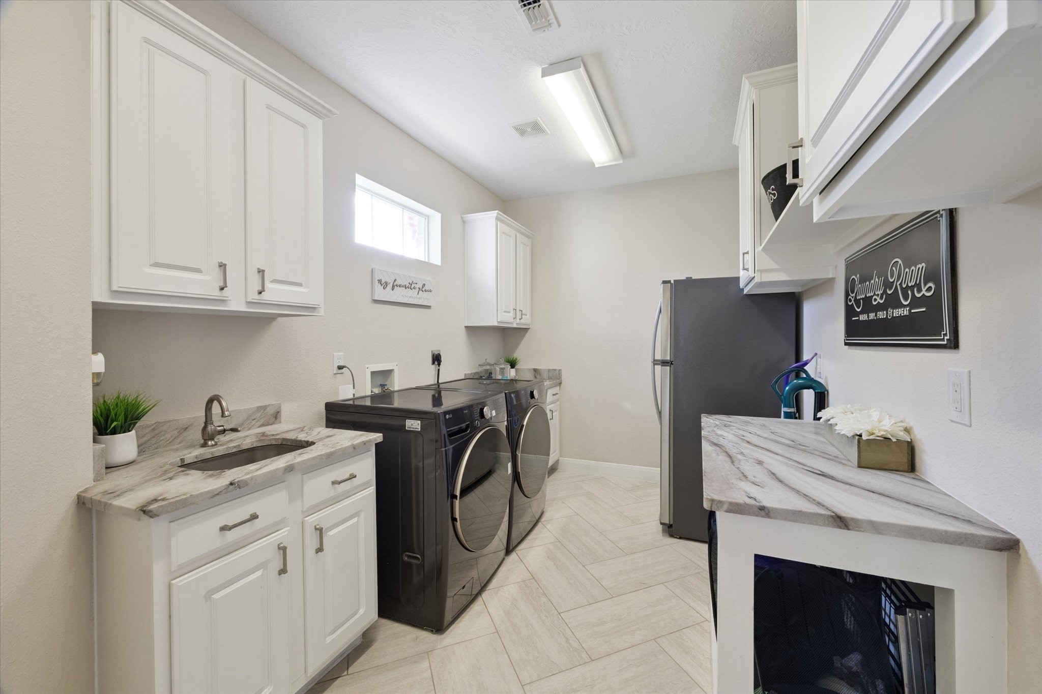 2904 Bridle Path Lane Friendswood, TX 77546 - Photo 31 of 49 To round up the first-floor tour, take a look at this exceptional laundry room—complete with a window for natural light, a utility sink for added convenience, a secondary refrigerator, and abundant storage space to keep everything organized and functional.