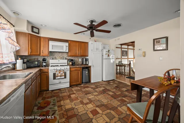 a kitchen with stainless steel appliances granite countertop a stove top oven a sink a dining table and chairs
