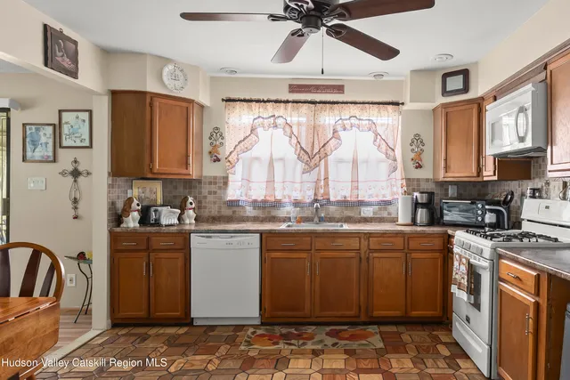 a kitchen with stainless steel appliances granite countertop a stove top oven a sink a counter space and cabinets