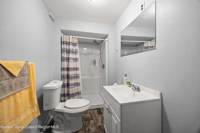 a bathroom with a toilet sink vanity and mirror